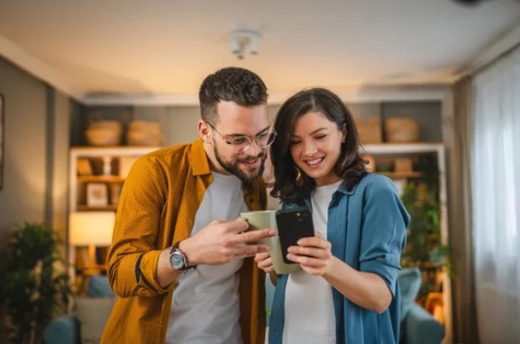 Duas pessoas consultando o celular juntas