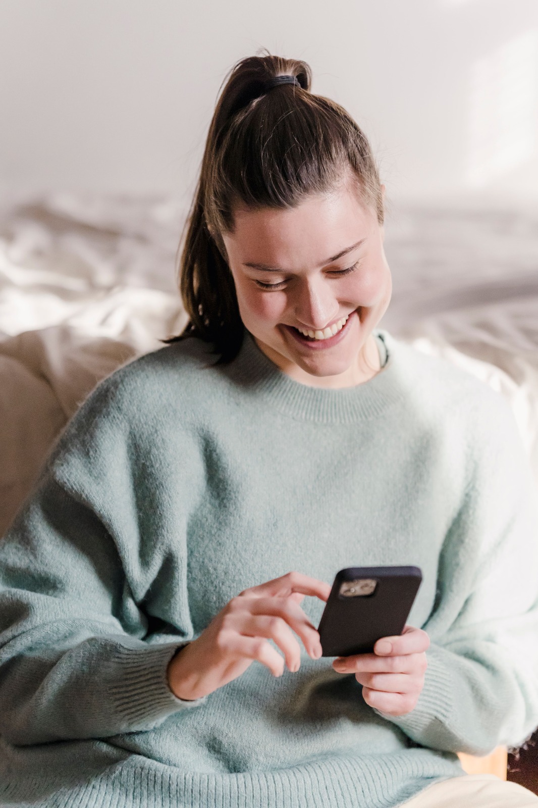 Pessoa sorrindo ao descobrir uma possibilidade de trabalho pelo celular